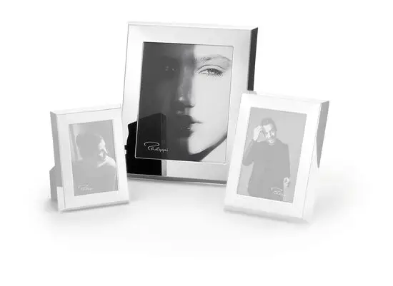 Tre moderne, rektangulære fotorammer med refleksiv finish. Indeholder sort-hvide fotografier.