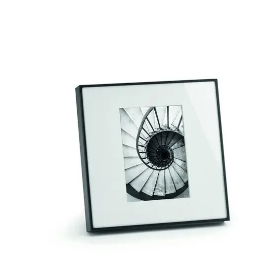 Firkantet ramme med sort kant, viser sort-hvidt foto af en spiraltrappe. Minimalistisk design.