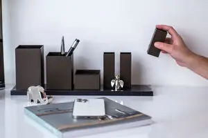 Skrivebordsarrangør med rektangulære beholdere på bakke. Hånd viser moduldesign. Telefon og notesbog.