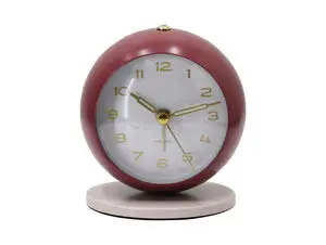 Rundt vækkeur i burgundy rød med hvid urskive, guldfarvede tal og visere på varm grå base.