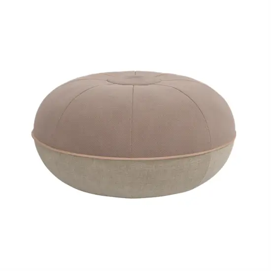 Rund pouf i varm sand og lys tone, med knap i midten og segmenter strålende ud fra centrum.