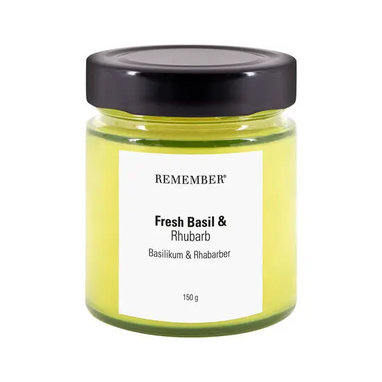 Duftlys i glas med sort låg, mærkat "Fresh Basil &amp; Rhubarb", voks i gul nuance.