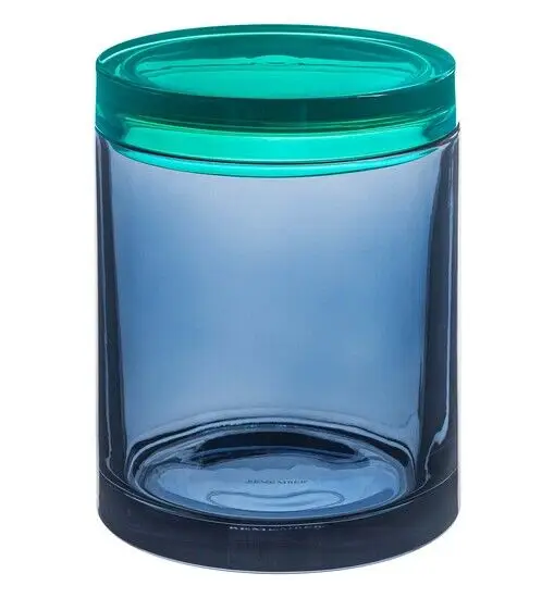 Stor cylindrisk glasbeholder med gennemsigtigt korpus og farvet låg, der skaber kontrast.