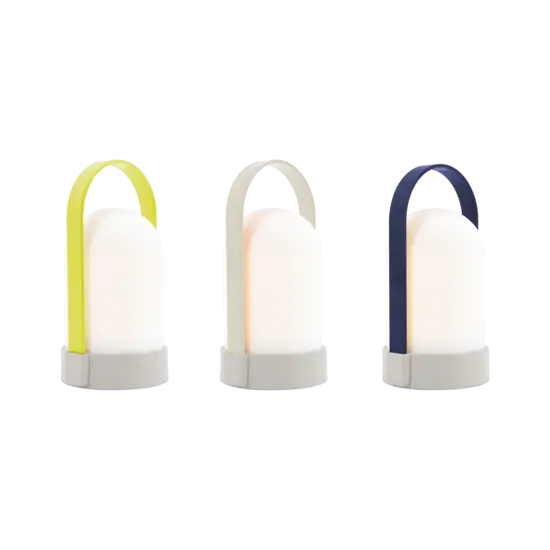 Tre små cylindriske lamper med håndtag i beige, mørkeblå og gul, på en rund base.