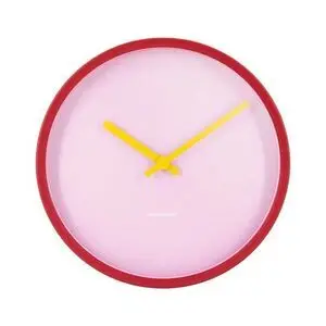 Rundt vægur med rød kant, lys pink urskive og gule visere. Minimalistisk design.