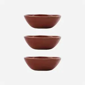 Tre røde skåle med enkel, afrundet form og glat overflade, stablet vertikalt.