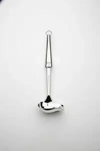 Skinnende, ergonomisk sauceske i metal med rundet skefuld og elegant design.