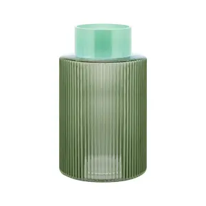 Grøn vase med lodrette riller og en glat, lys grøn top. Elegant og moderne design.